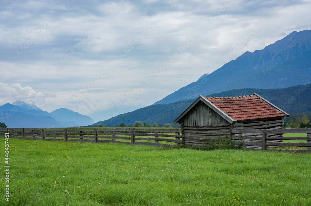 wooden cabin and fence with mountains in a background (Mieming area)
