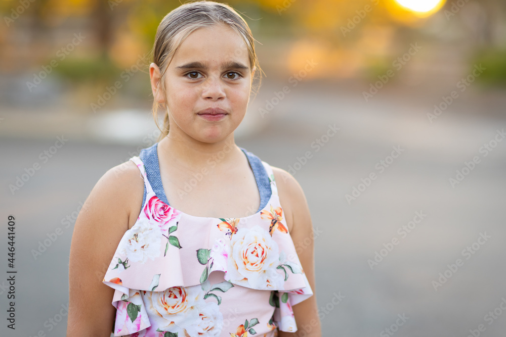 upper body view of young girl standing by herself looking at the camera upper body view of young girl standing by herself looking at the camera