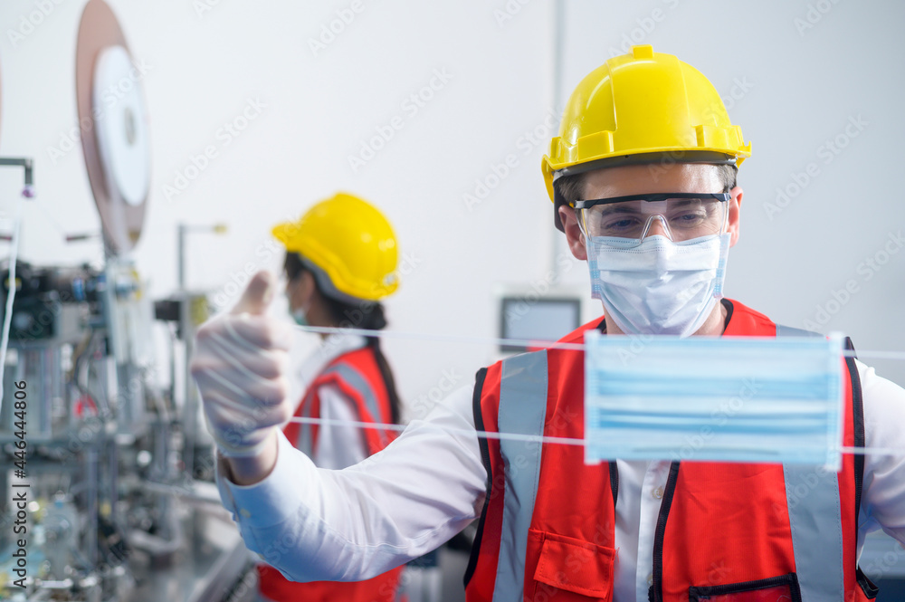 Quality control (QC) engineer monitoring and checking machine system in manufacturing factory Quality control (QC) engineer monitoring and checking machine system in manufacturing factory