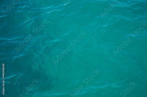 Aerial view of aquamarine sea surface. Rough sea texture. Top view natural background of rippled sea-green sea water. Marine theme with copy space.
