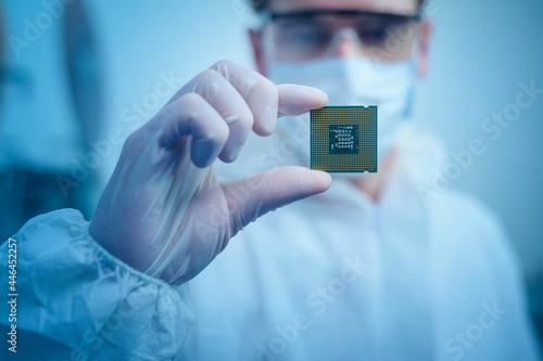 Engineer man  in sterile suit is holding Microchip with symbols in modern design factory  , futuristic and artificial intelligence concept photo