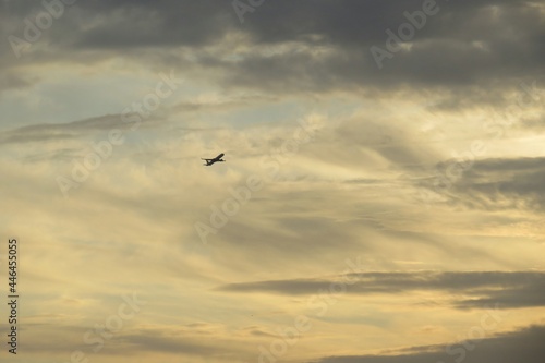Airplane in yellow sky at sunset, natural background 