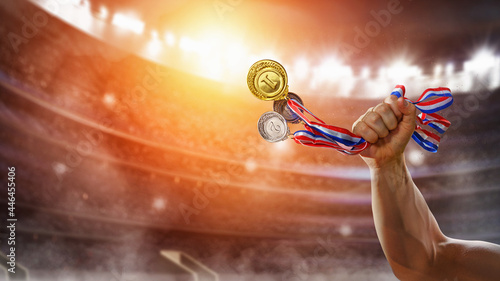 different medals in hand a chempion in the stadium - Victory Concept