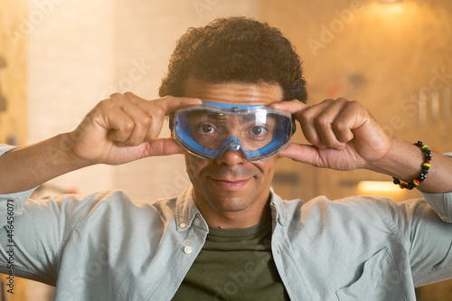 Portrait of a carpenter putting on safety goggles