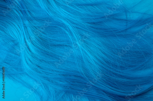 Anime and manga fashion, feminism and and social justice warrior concept with vivid turquoise coloured artificial hair isolated on blue background with copy space