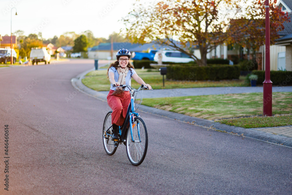 Happy young Australian woman on a bike riding down the road Happy young Australian woman on a bike riding down the road