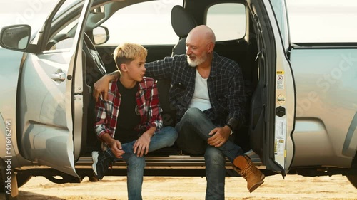 A happy son and his father are talking while travelling on the pickup car on nature photo