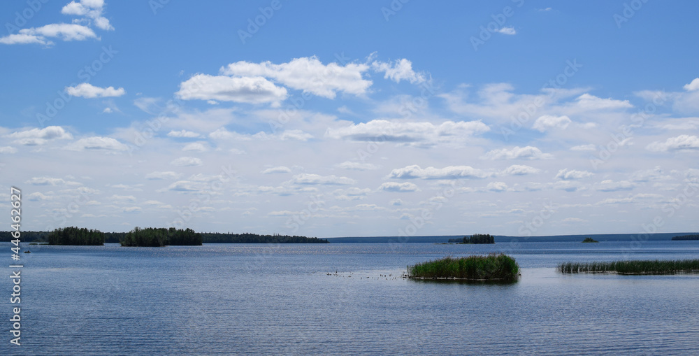 Beautiful summer landscape. Bright blue sky, white clouds, lake, forest, beautiful nature. Southern Urals, Chelyabinsk region (Russia). Lake Uvildy. Ilmensky reserve.