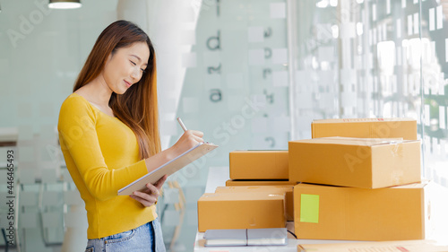 Start a business smeA beautiful Asian businesswoman works with boxes and laptops to take orders from customers and enjoys working from home online selling ideas and delivery. photo