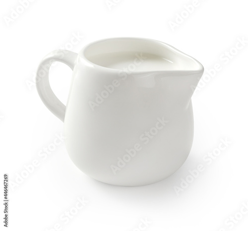 Ceramic milk jar isolated on white background. Milk pitcher for package design. Porcelain creamer pitcher with milk on white. photo