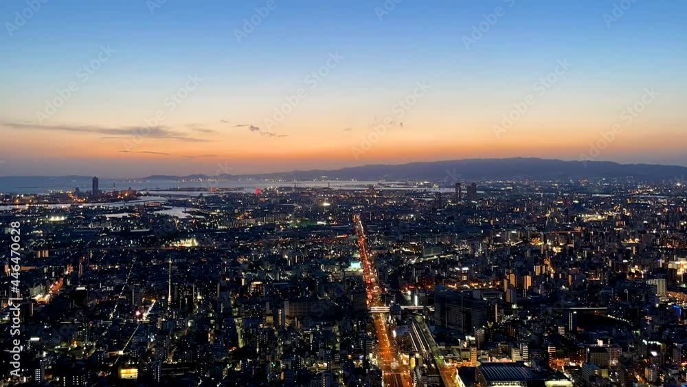OSAKA, JAPAN : Aerial high angle sunrise view of CITYSCAPE of OSAKA. View of buildings and street traffic around Osaka bay and Kobe port. Long time lapse wide view zoom in shot, night to morning. OSAKA, JAPAN : Aerial high angle sunrise view of CITYSCAPE of OSAKA. View of buildings and street traffic around Osaka bay and Kobe port. Long time lapse wide view zoom in shot, night to morning.