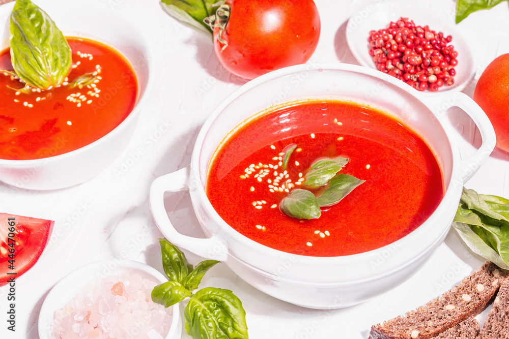 Bowls with homemade tomato soup. Ripe vegetables, fresh basil leaves, breadsticks, aromatic spices Bowls with homemade tomato soup. Ripe vegetables, fresh basil leaves, breadsticks, aromatic spices