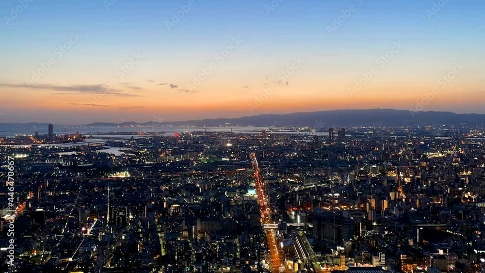 OSAKA, JAPAN : Aerial high angle sunrise view of CITYSCAPE of OSAKA. View of buildings and street traffic around Osaka bay and Kobe port. Long time lapse wide view zoom out shot, night to morning. OSAKA, JAPAN : Aerial high angle sunrise view of CITYSCAPE of OSAKA. View of buildings and street traffic around Osaka bay and Kobe port. Long time lapse wide view zoom out shot, night to morning.