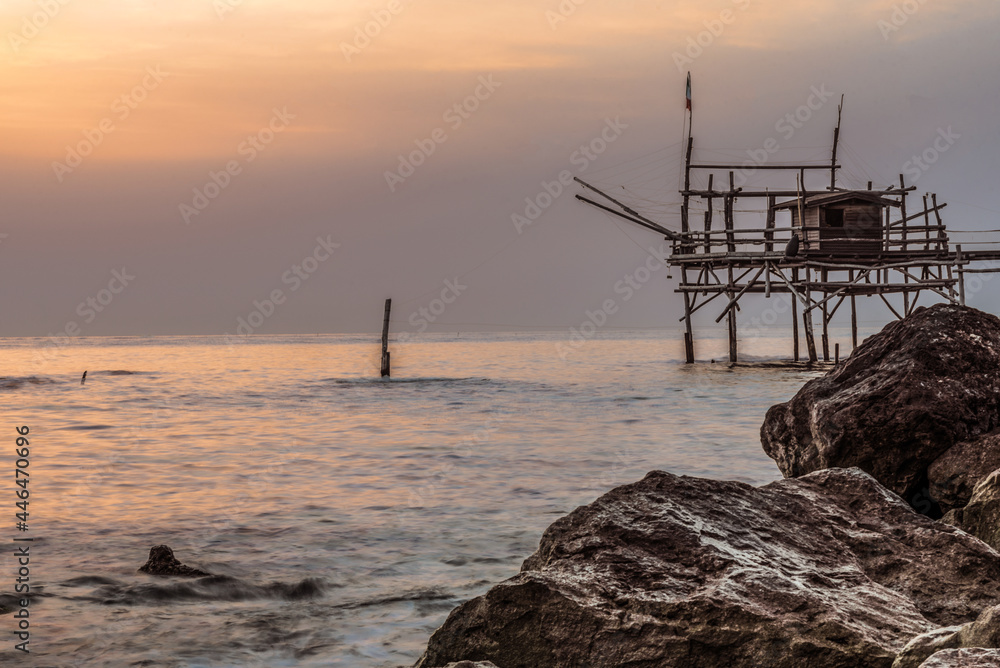 June 2021, San Vito Chietino, Abruzzo, Italy. Trabocchi coast.
View of the Turchino Trabocco. Ancient fishing machine in the dawn light with silky sea
