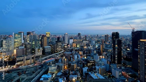 UMEDA, OSAKA, JAPAN : Aerial high angle sunset view of CITYSCAPE of OSAKA. View of buildings and street around Osaka and Umeda station. Wide view time lapse tracking shot, dusk to night. photo