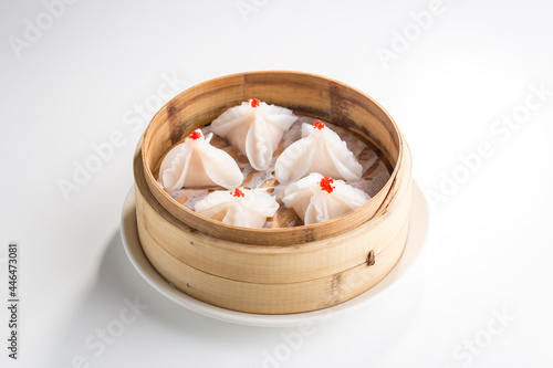 Chinese dim sum dumplings in bamboo basket isolated on white background