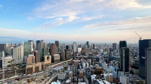 UMEDA, OSAKA, JAPAN : Aerial high angle sunset view of CITYSCAPE of OSAKA. View of buildings and street around Osaka and Umeda station. Wide view time lapse zoom out shot, dusk to night. photo