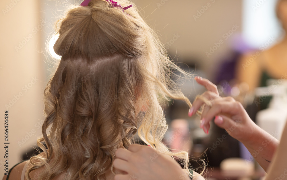 Fototapeta premium Master hairdresser makes hair style girl with hairdryer and hair care products
