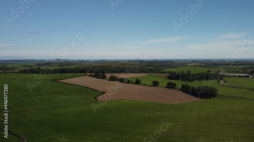 Drone of bare earth field surrounded by green fields
