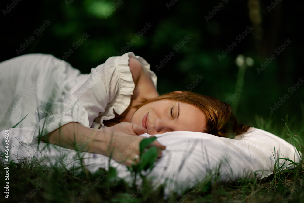 Healthy sound sleep. Rest, relaxation in the forest. Woman sleeps on a pillow on a green glade in the forest.