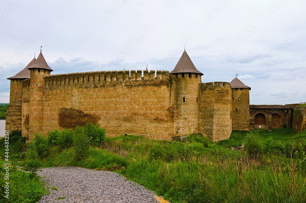Amazing wide-angle landscape photo of medieval castle with high stone wall and towers. Blue sky background. Low perspective view. Travel and tourism concept Amazing wide-angle landscape photo of medieval castle with high stone wall and towers. Blue sky background. Low perspective view. Travel and tourism concept