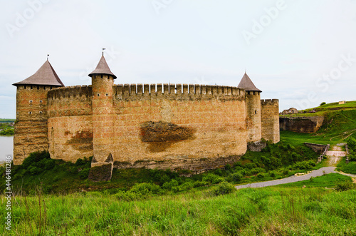 Wide angle landscape view of ancient fortress with high stone wall and towers. Blue sky background. Famous touristic place and romantic travel destination