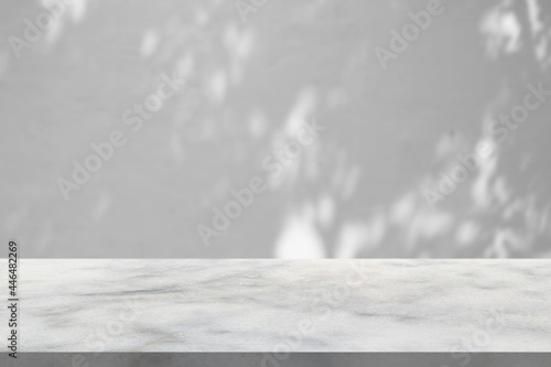 Marble table with tree shadow drop on white wall background for mockup product display photo