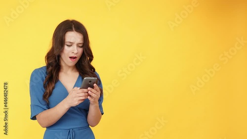 Mobile app. Advertising background. Online search. Social media. Surprised impressed woman using phone with wow reaction isolated on orange empty space. photo