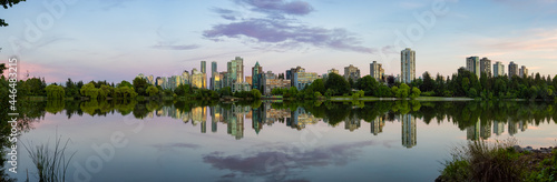 Fototapeta Naklejka Na Ścianę i Meble -  Panoramic View of Lost Lagoon in famous Stanley Park in a modern city with buildings skyline in background. Colorful Sunset Sky. Downtown Vancouver, British Columbia, Canada.