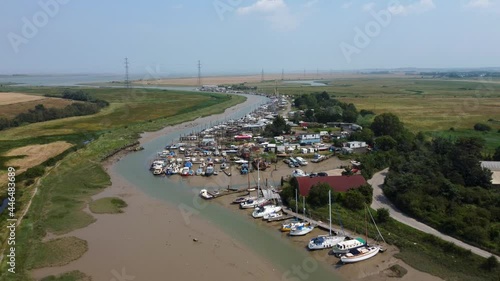 4K drone video flying away from a lot of boats in a creek photo