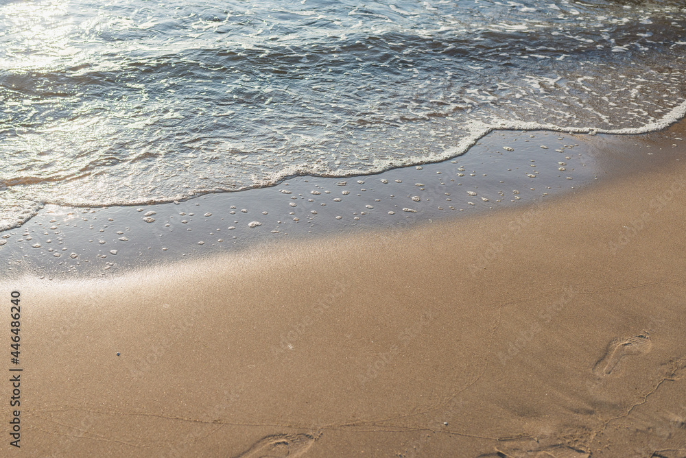 Soft wave of the sea on the sandy evening beach.Soft focus,blurred image. Soft wave of the sea on the sandy evening beach.Soft focus,blurred image.
