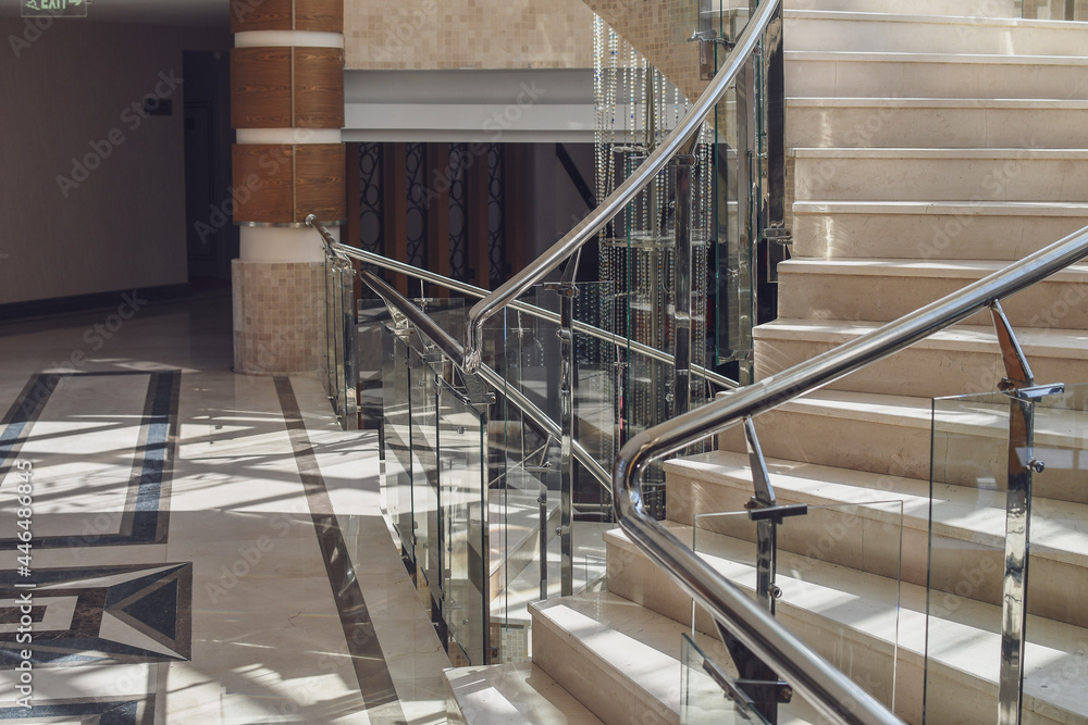 Fototapeta premium Detail of empty marble rounded staircase in the interior. Top view in perspective. Selective focus.
