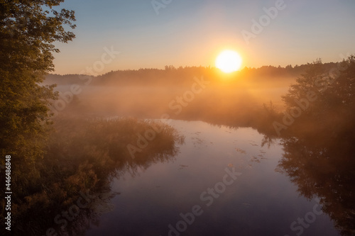 Beautiful small river covered with fog in the morning. Rural landscape at sunrise