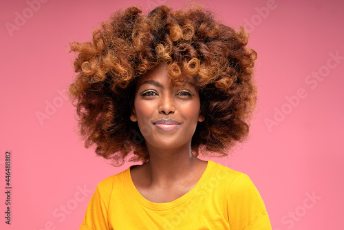 Happy beautiful afro girl with glamour summer makeup and curly hair smiling to the camera