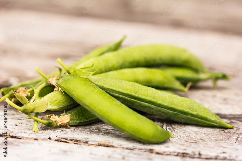 Green pea pods on wooden background. Shallow focus, macro, stock photo Green pea pods on wooden background. Shallow focus, macro, stock photo