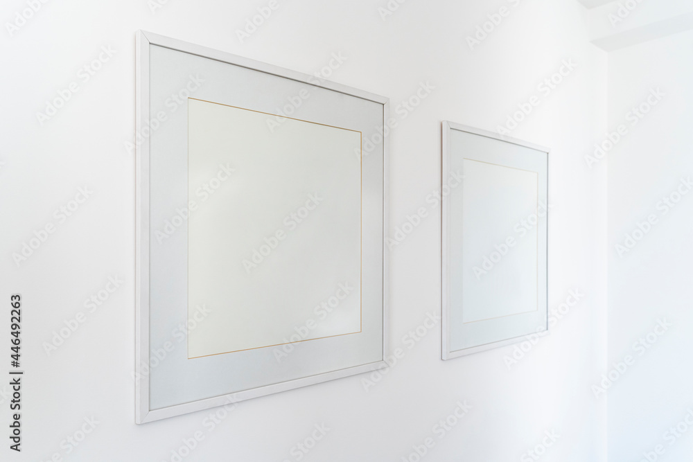 Empty square white frame, poster white canvas mock up on a white wall, living room, template angle view gallery, home decoration Empty square white frame, poster white canvas mock up on a white wall, living room, template angle view gallery, home decoration