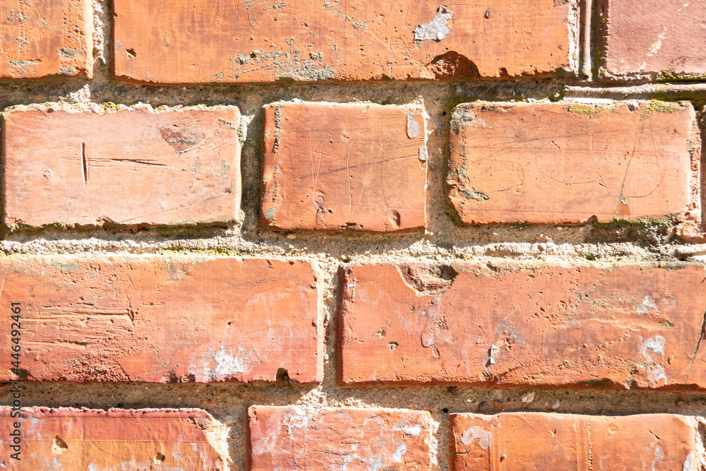 Obraz premium Fragment of a brick wall with layers of cement. Brick background. Close-up.