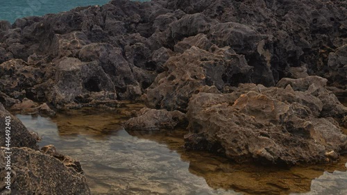 Detailed view of volcanic coastline with high cliffs and waves breaking over volcanic rocks, Portugal.