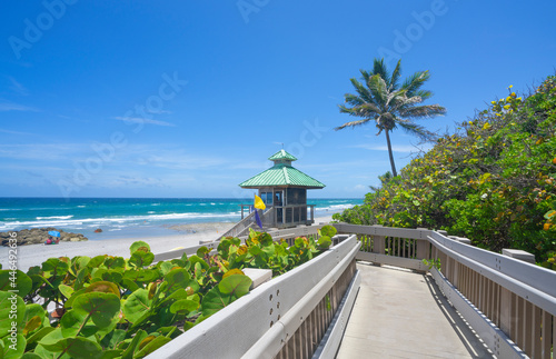 Fotografia Boardwalk to beautiful Florida beach with crystal clear water and red rocks