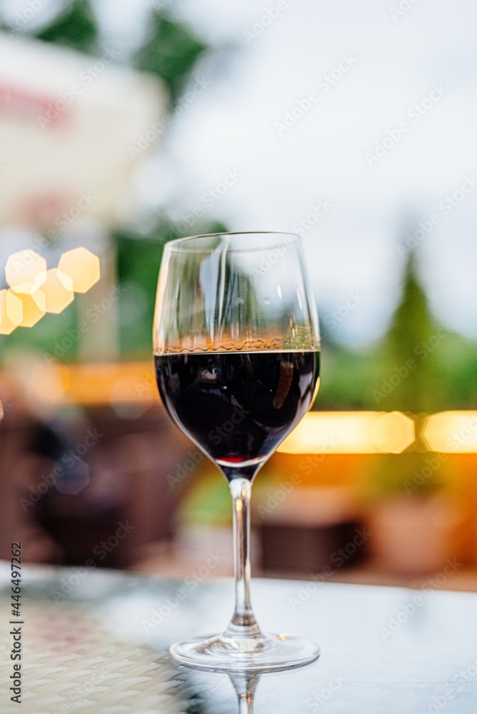 A glass of red wine stands on a table in a restaurant.
