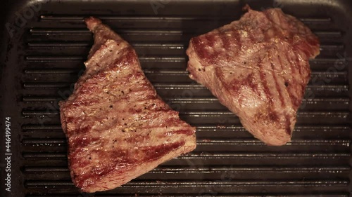 Beef steak is fried in a pan. Marbled beef on a hot grill pan.