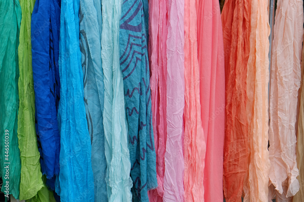 Background of many colorful pashmina scarves hanging