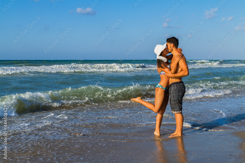 Attractive young couple in bikini and shorts at the beach. Attractive young couple in bikini and shorts at the beach.