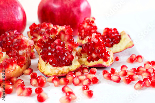Close-up of fresh pomegranate slices, on white background. Jewish new year symbol.