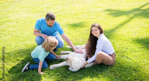 happy parents with kid boy play with dog. mom dad and son love relax together.