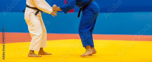 Two judo fighters in white and blue uniform. Horizontal sport poster, greeting cards, headers, website