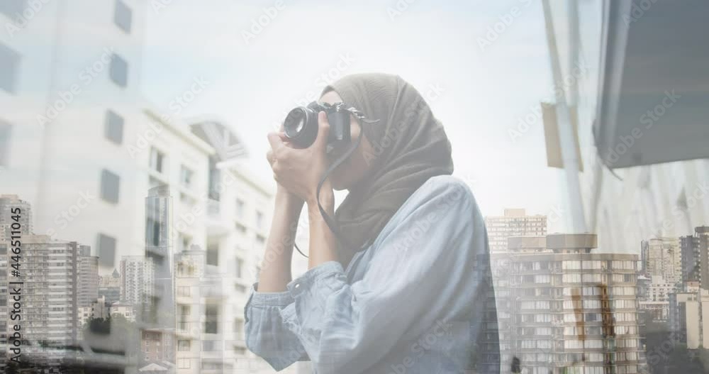 Animation of asian woman in hijab using camera over cityscape Animation of asian woman in hijab using camera over cityscape