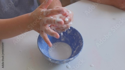 Smart Curious School Kid Playing With Homemade Water and Corn Starch Based Mixture Non Newtonian Oobleck Fluid STEM  photo