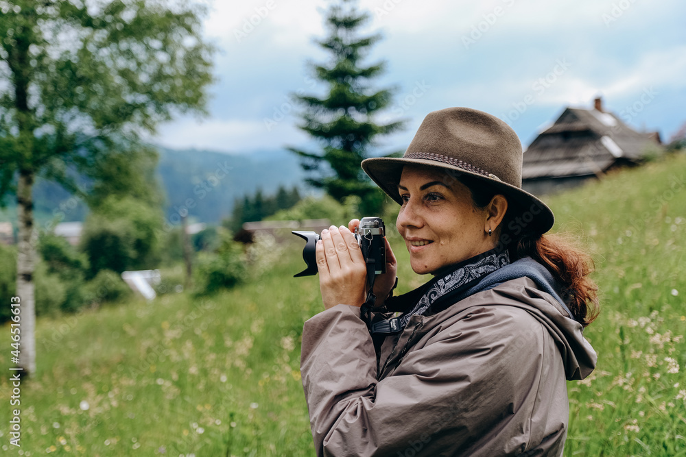 Woman photographer travels in the mountains in summer. Hiking in Europe. A woman photographs alpine landscapes.