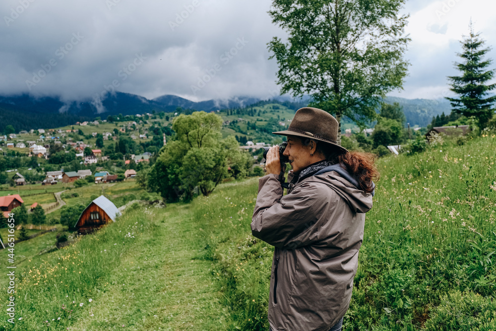 Woman photographer travels in the mountains in summer. Hiking in Europe. A woman photographs alpine landscapes. Woman photographer travels in the mountains in summer. Hiking in Europe. A woman photographs alpine landscapes.